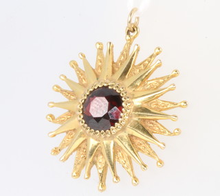 A 9ct yellow gold star shaped garnet set pendant, 3.4 grams gross, 24mm