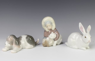 A Lladro figure of a rabbit 5905 12cm,  a ditto of a sleeping hound 17cm and an a eskimo boy with polar bear cub 10cm  