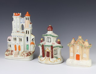 A Staffordshire figure of a castle 23cm, a ditto money bank in the form of a country cottage 16cm and a floral encrusted cottage 14cm 