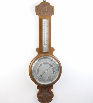A 1930's aneroid barometer with 20cm silvered dial contained in a carved oak case (top to thermometer case is missing) 