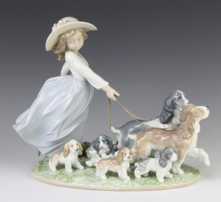 A Lladro figure of a young lady walking 2 dogs and 5 puppies 6784 30cm 