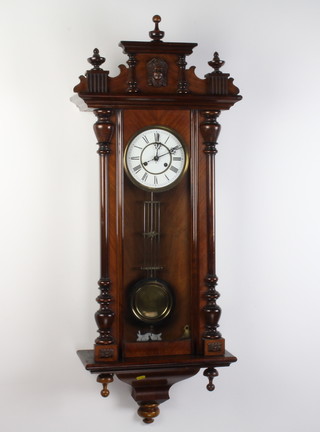 A Vienna style striking regulator with 16cm circular enamelled dial, Roman numerals, contained in a carved walnut case, complete with grid iron pendulum 