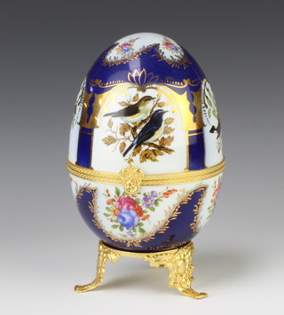 A 20th century painted porcelain gilt metal mounted egg decorated with birds and flowers 23cm 