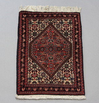 A blue and red ground Persian slip rug with diamond medallion to the centre within a 3 row border 64cm x 43cm 
