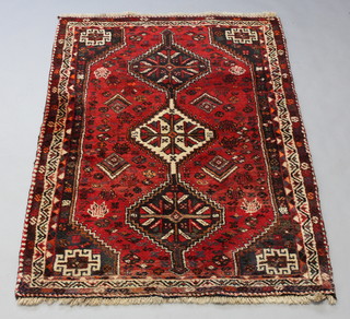 A red ground Afghan rug with 3 stylised diamonds to the centre 170cm x 121cm 