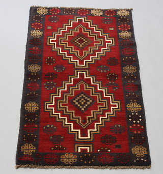 A brown and black ground Belouche rug with 2 stylised diamonds to the centre 145cm x 88cm 