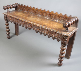 A Victorian carved oak hall bench with raised back and carved apron, raised on bobbin turned supports 60cm h x 120cm w x 26cm d  