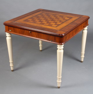 A Hurtado square inlaid walnut games table, the removable top inlaid a chess board to reveal a card table, the sides fitted 4 drinks slides, raised on white painted turned supports 76cm h x 90cm w x 90cm d  