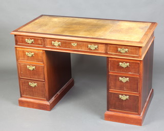 A mahogany kneehole pedestal desk with green inset leather writing surface, above 1 long and 8 short drawers with brass ring drop handles 77cm h  x 123cm w x 62cm d 