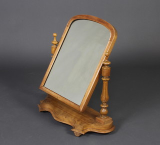 A Victorian arched plate dressing table mirror contained in a bleached mahogany swing frame, turned fluted columns to the side, the base of serpentine outline 77cm h x 67cm w x 25cm w 