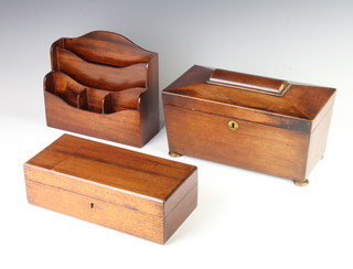 A 19th Century mahogany twin compartment tea caddy of sarcophagus form, the interior fitted an associated mixing/sugar bowl, raised on bun feet 15cm h x 30cm w x 15cm d, an Edwardian mahogany 3 sectioned stationery rack 20cm x 29cm x 24cm and a rectangular mahogany trinket box with hinged lid 9cm x 28cm x 13cm d 