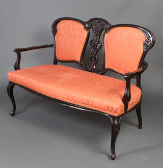 An Edwardian pierced ebonised and carved 4 piece drawing room suite comprising 2 seat sofa upholstered in red material, a pair of open arm chairs with pierced vase shaped slat backs and over stuffed seats raised on cabriole supports and a further pair of standard chairs 