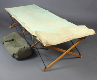 A military issue canvas folding camp bed together with a canvas kit bag 