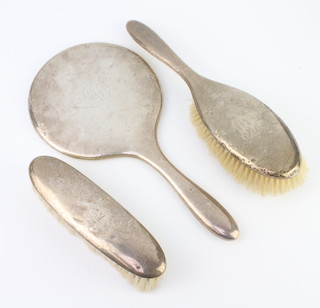 A silver backed hand mirror Chester 1913, a clothes brush and hair brush, different marks