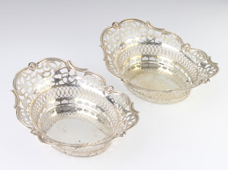 A pair of Edwardian pierced and repousse silver bon bon dishes with scroll decoration and mask heads, Birmingham 1908, 325 grams