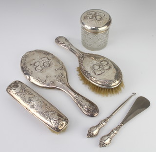 A Victorian repousse silver Reynolds Angels dressing table set comprising hair brush, clothes brush, hand mirror, together with a circular silver lidded jar Birmingham 1897, 1898 and a mounted shoe horn and button hook 