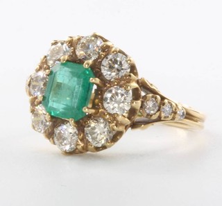 An 18ct yellow gold emerald and diamond cluster ring, the centre stone 1.20ct surrounded by brilliant cut diamonds 1.35ct, size N 1/2