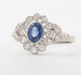A platinum oval sapphire and diamond cluster ring, the sapphire approx 1.2ct surrounded by brilliant cut diamonds approx. 0.2ct, size Q 1/2 