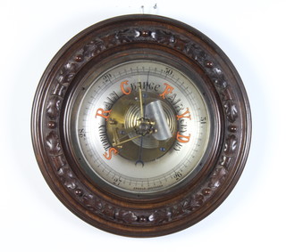 An Edwardian aneroid barometer and thermometer contained in a carved mahogany circular case 34cm diam. 