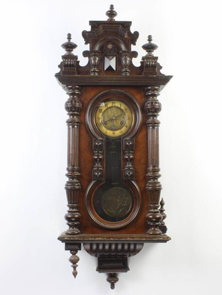 A 19th Century Vienna style regulator with paper dial, Arabic numerals and grid iron pendulum, contained in a walnut case 