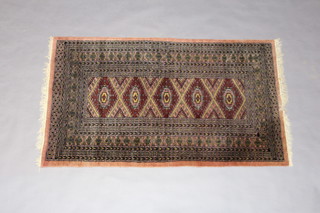 A pink ground Bokhara rug with 5 stylised diamonds to the centre within a multi row border 162cm x 97cm 