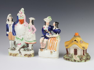 A Staffordshire style pastel burner in the shape of a cottage 12cm, a ditto of a courting couple 20cm and figures beside a clock 25cm 