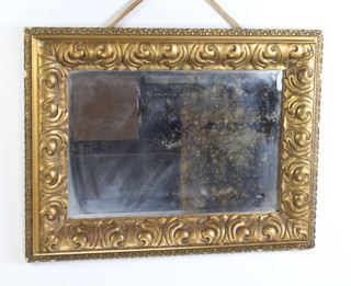 A 19th Century rectangular bevelled plate wall mirror contained in a carved gilt cushion shaped frame 75cm h x 57cm w 