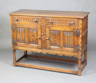 A 17th Century style carved oak sideboard, with arcaded and linenfold decoration, fitted 2 drawers above double cupboard, raised on turned and block supports 90cm h x 122cm w x 45cm d 