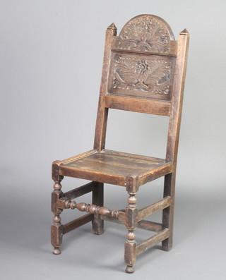A Victorian 17th Century style carved oak hall chair with arched back and solid seat, raised on turned and block supports 