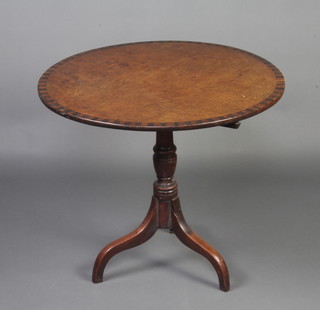 A circular crossbanded Georgian mahogany snap top tea table raised on a turned column and tripod base 68cm h x 79cm diam. 