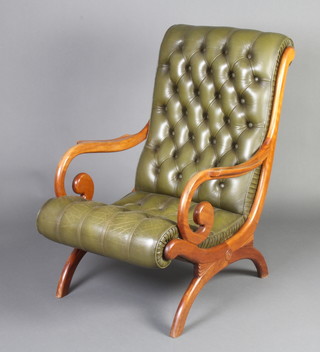 A Georgian style mahogany framed slipper open arm chair, upholstered in green buttoned back leather, raised on X framed supports