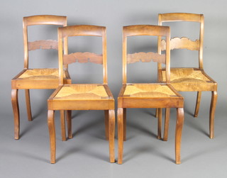 A set of 4 19th Century French fruitwood bar back dining chairs with woven rush drop in seats, raised on sabre supports 