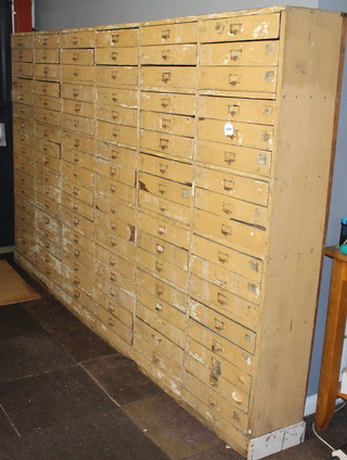 A 19th Century Continental cream painted pine range of 102 shallow drawers 178cm h x 302cm w x 30cm d 
