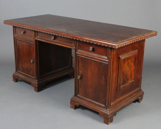 A Victorian mahogany free standing counter/desk with carved apron, fitted 1 long and 2 short drawers, the pedestals fitted cupboards enclosed by panelled doors, raised on bracket feet 80cm h x  163cm w x 72cm d 