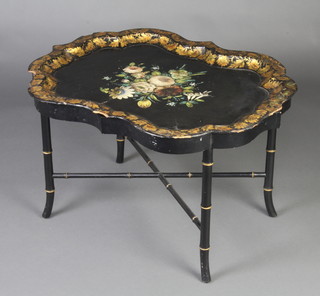 A Victorian black and floral patterned papier-mache tray, raised on an associated faux bamboo stand 50cm h x 80cm w x 61cm 