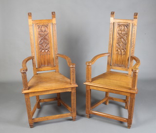 A pair of Arts and Crafts style carved oak high back open arm throne chairs with solid seats raised on square tapered supports with box framed stretcher 