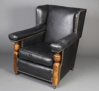 A 1930's club style oak framed armchair upholstered in black rexine 
