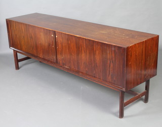 A mid 20th Century rosewood and oak sideboard, fitted 5 trays enclosed by a tambour shutter, raised on square supports 74cm h x 204cm w x 51cm d. Cites certificate reference