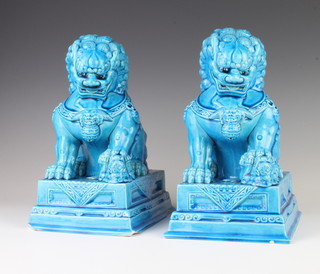 Two Chinese turquoise glazed figures of Shi Shi, each with a small Shi Shi beneath his paw, raised on rectangular bases 23cm 
