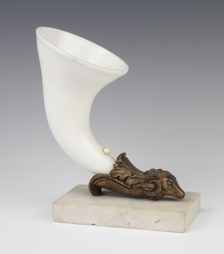 A ceramic cornucopia in a gilt rams head holder, raised on a white marble base 22cm, the cornucopia and base are chipped 