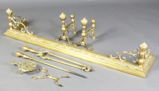A Victorian brass fire curb 29cm h x 139cm w x 28cm d together with a pair of matching fire dogs, tongs and poker, an associated pierced brass trivet and  a pair of fire tongs  