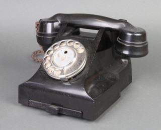 A black Bakelite dial telephone, the base marked 332F S 56/3A 