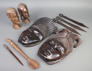 Two Nigerian carved hardwood masks 36cm x 22cm, 2 ditto carved portrait busts of a lady and gentleman 20cm x 6cm x 8cm, 4 carved hardwood paperknives and a spoon 