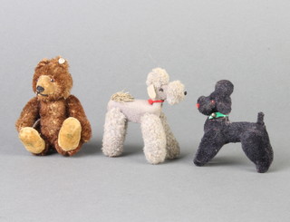 A brown Steiff bear with articulated limbs 9cm with stud to ear, a felt figure of a black poodle the base marked MC West German original 5cm x 5cm and a felt figure of a grey poodle 6cm 