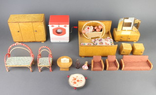 A 1950's Birdseye Maple dolls house bedroom suite comprising double bed, wardrobe, dressing table with mirror over, pair of bedside cabinets and a 1930's style 3 piece suite, a bentwood sofa and armchair, a rocking crib containing 4 celluloid dolls, table lamp, table and a Josephine spin dryer 