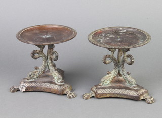 A pair of Regency style circular bronze candlesticks with dolphin supports raised on triform bases 12cm h x 12cm w 