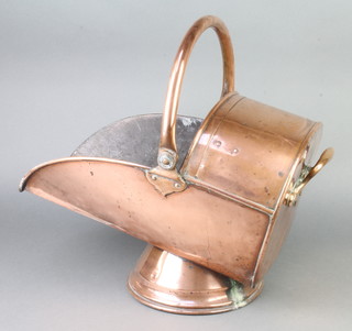 A copper helmet shaped coal scuttle with swing handle 
