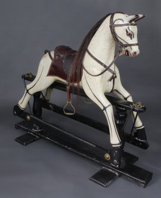 A good quality contemporary dappled grey rocking horse 120cm h x 150cm l x 50cm w, raised on an ebonised base 