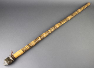 A carved bamboo cane with gilt metal terminal in the form of a 2 faced head 