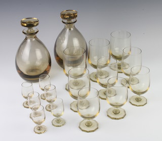 An Art Deco suite of amber glassware comprising 2 baluster decanters, 6 totts, 6 wines and 6 large wines 